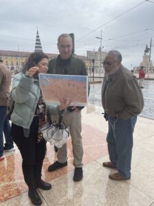 Three people standing together looking at a map and talking.