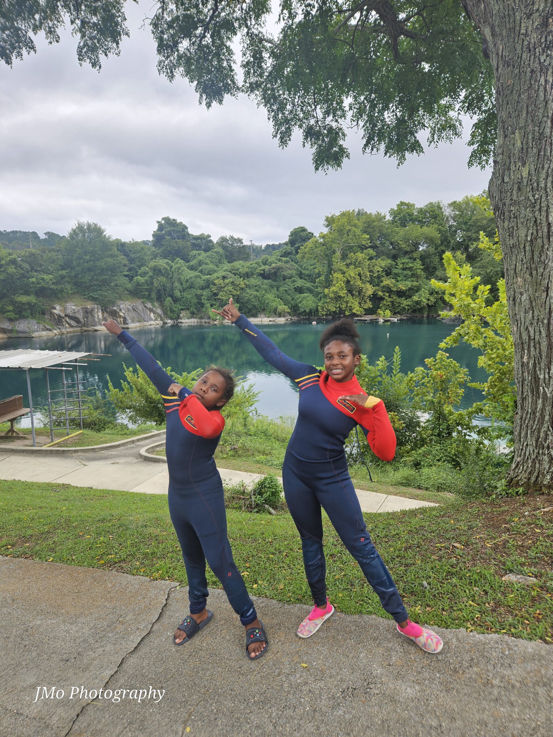 Boy and Girl pose in dive suits and swim at the camera