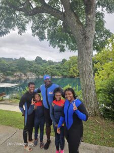 Five people swim at the camera wearing dive suits