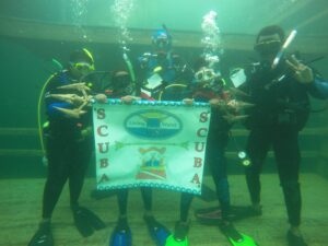 Divers pose with sign underwater