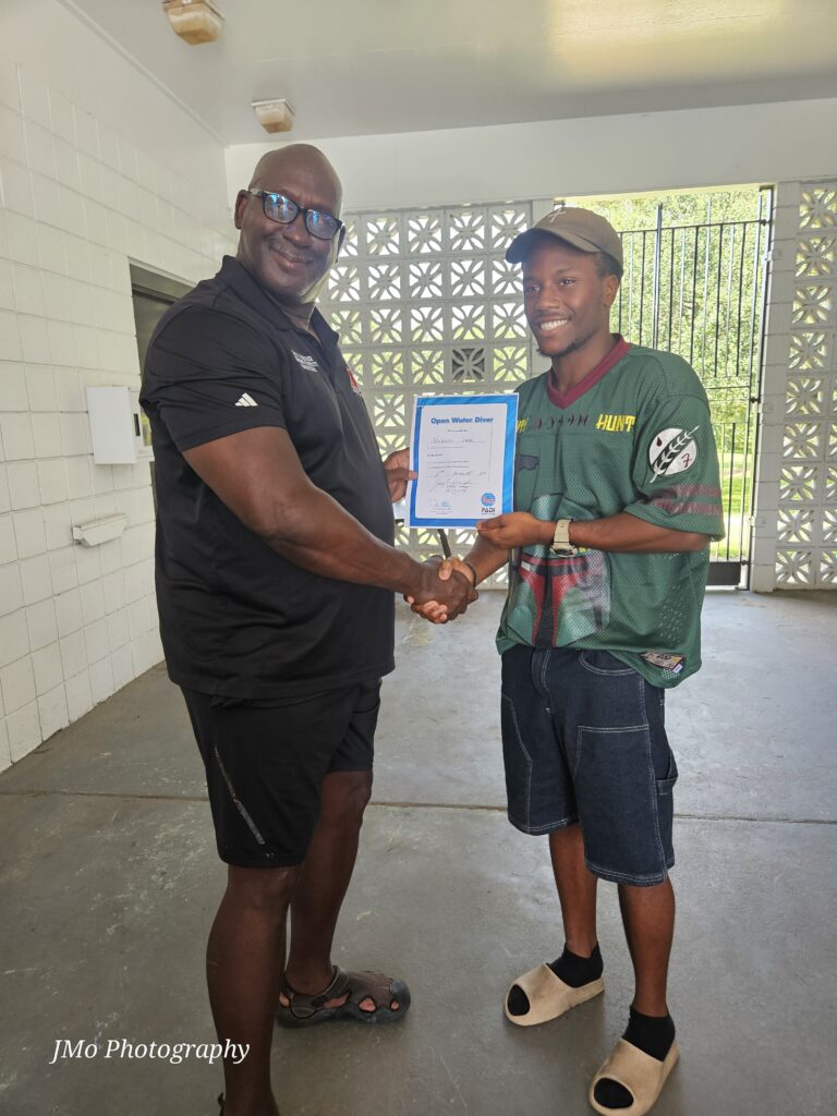 Two men standing shaking hands and holding a certificate