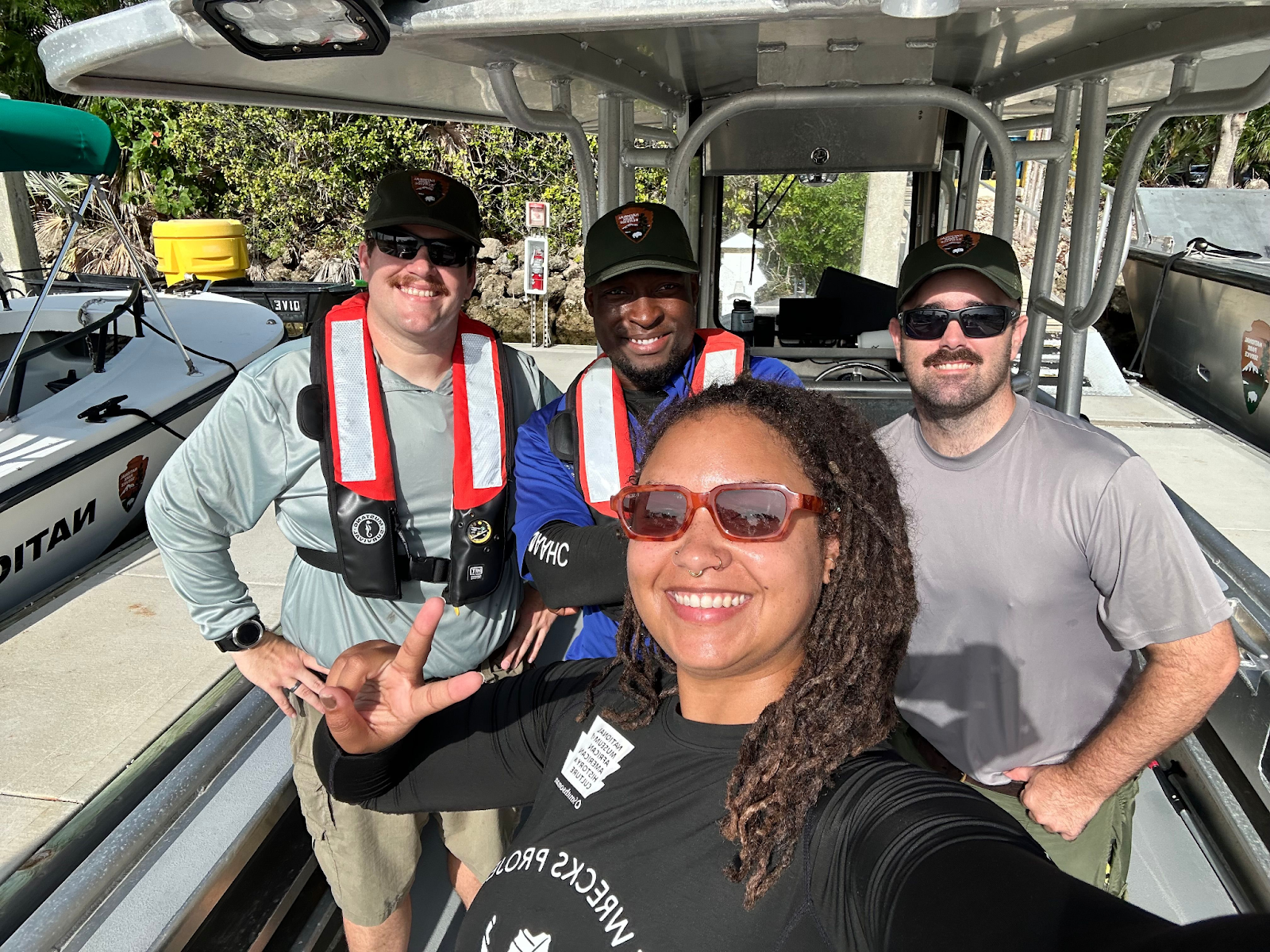 Four people posing for a selfie on a boat