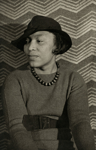 Woman wearing hat looks to the left of the camera